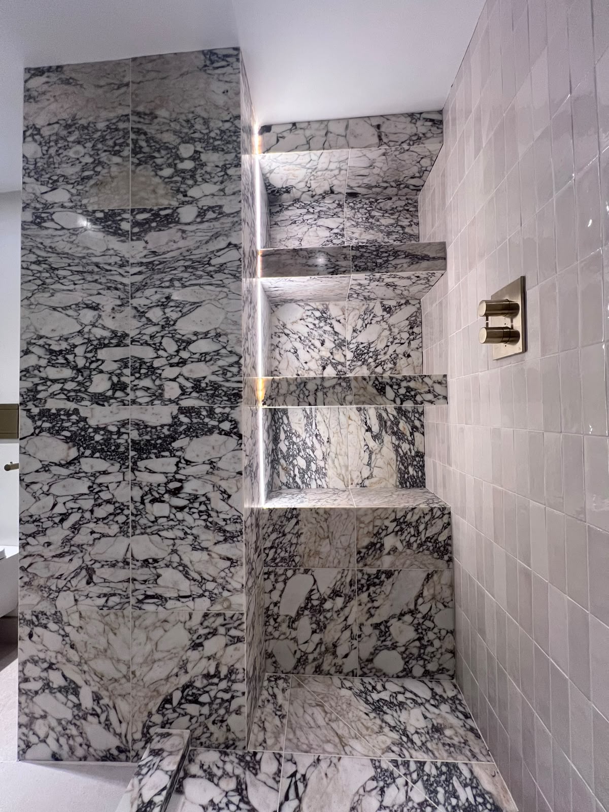 Mitred edge tiling to marble shelves in a Kent shower, no trims