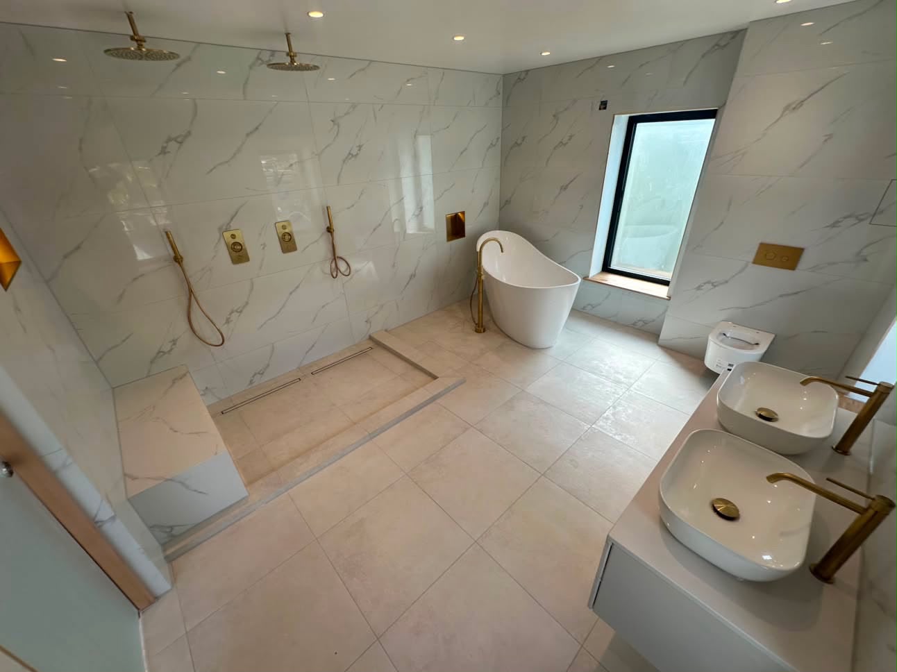 Completed bathroom refurbishment in Kent with marble-effect tiling and freestanding bath, serving Westerham