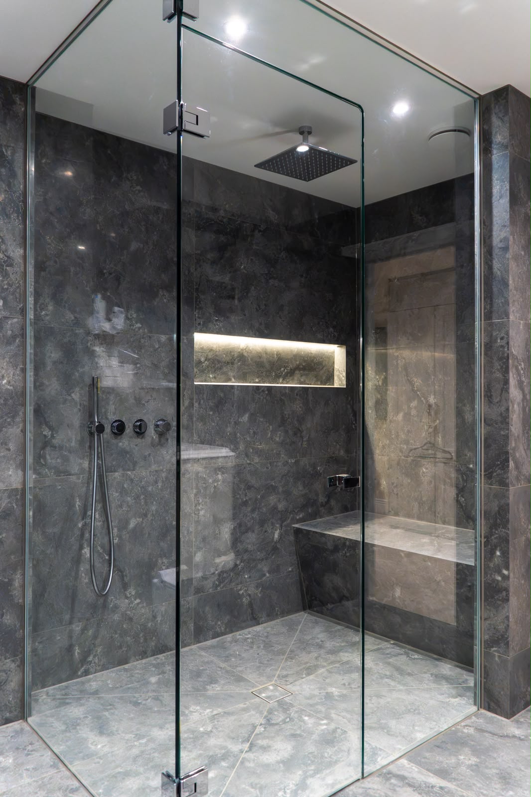 Wetroom installation in Kent with dark marble-effect tiling, level access shower and illuminated niche