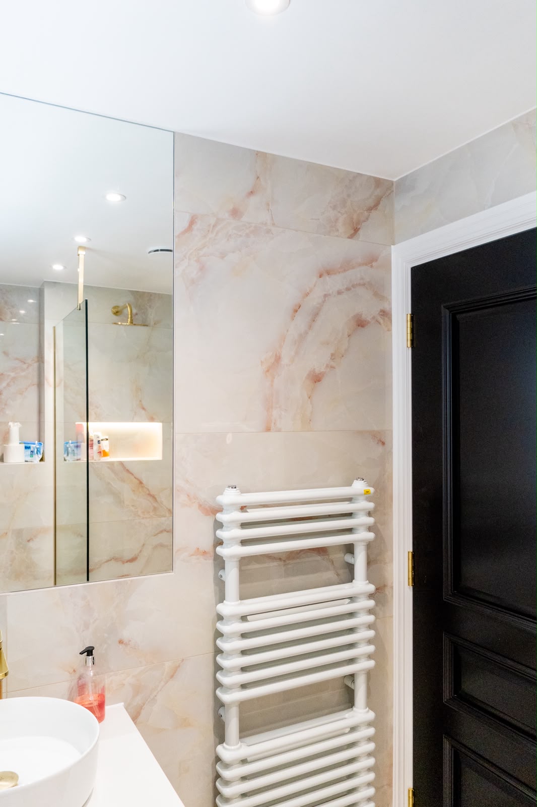 Pink onyx-effect natural stone tiling in a Kent shower room