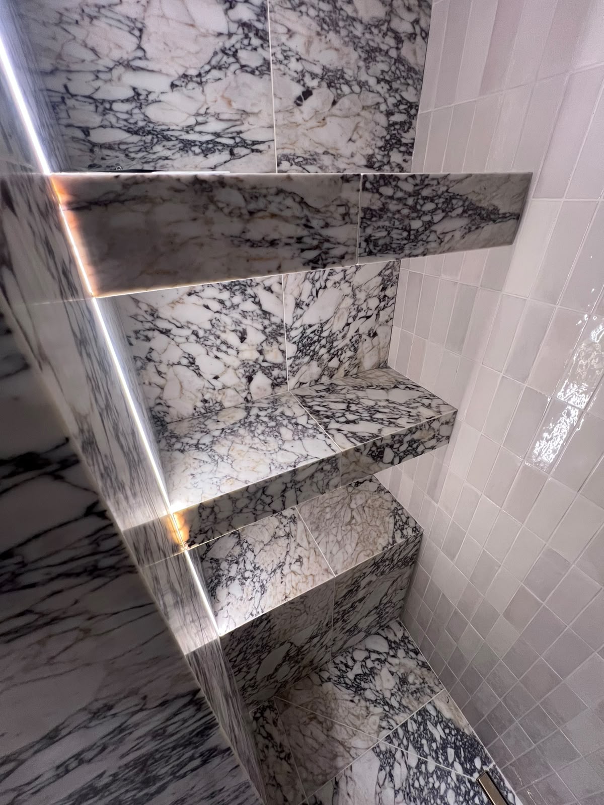 Mitred edge tiling to illuminated marble shower shelves in Kent, no trims
